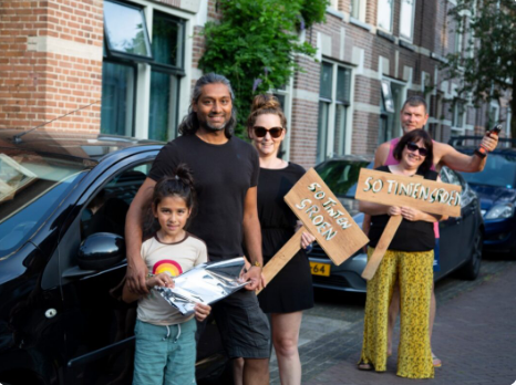 Mensen in de vooruin die een bordje vasthouden, odru asbestdaken Thuisbijeenkomst